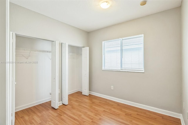 3156 NE 4th St, Homestead, FL 33033 - unfurnished bedroom featuring two closets and light wood-style flooring