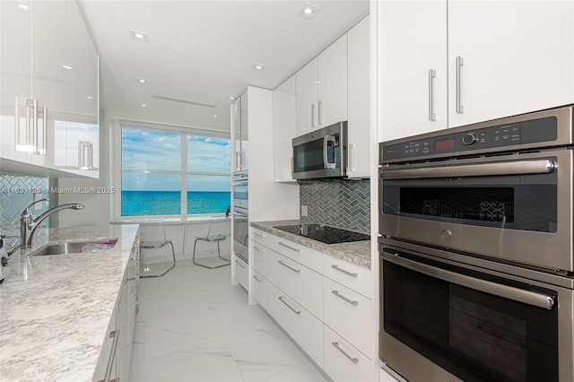 9511 Collins Ave Unit 1502, Surfside, FL 33154 - kitchen featuring stainless steel appliances, modern cabinets, and white cabinets