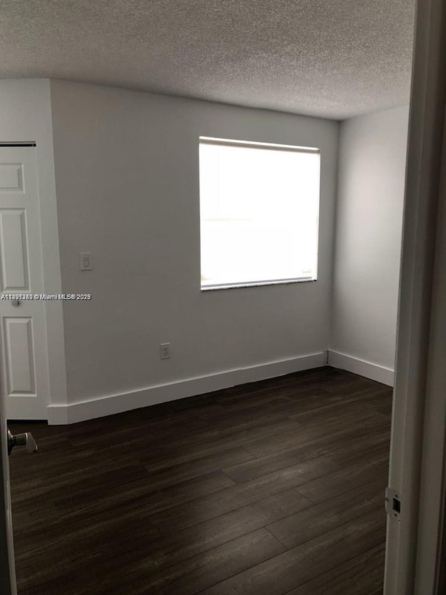 8670 NW 6th Ln Unit 4-208, Miami, FL 33126 - empty room with a textured ceiling and dark wood-style flooring