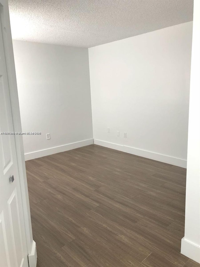 8670 NW 6th Ln Unit 4-208, Miami, FL 33126 - spare room with dark wood finished floors and a textured ceiling