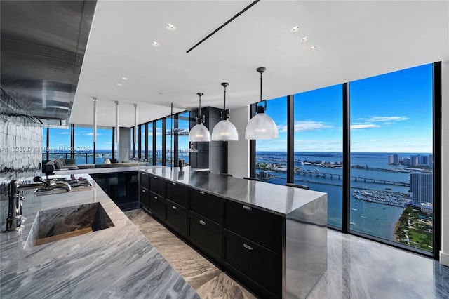 788 NE 23rd St Unit 5401, Miami, FL 33137 - kitchen featuring dark cabinets, expansive windows, modern cabinets, stainless steel gas cooktop, and a water view