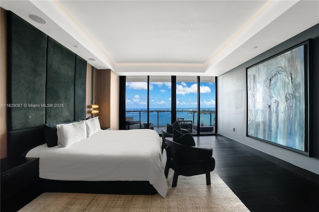 788 NE 23rd St Unit 5401, Miami, FL 33137 - bedroom featuring a wall of windows, a water view, dark wood finished floors, access to exterior, and a tray ceiling