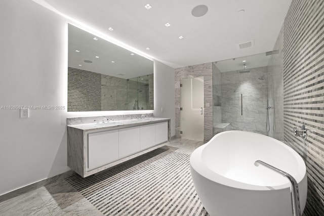 788 NE 23rd St Unit 5401, Miami, FL 33137 - full bath featuring tile walls, a freestanding tub, a marble finish shower, double vanity, and recessed lighting