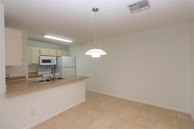 18328 NW 68th Ave Unit P, Hialeah, FL 33015 - kitchen featuring white appliances, a peninsula, pendant lighting, light countertops, and cream cabinetry