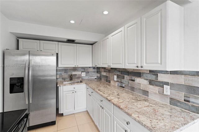 300 SW 134th Way Unit 413E, Pembroke Pines, FL 33027 - kitchen featuring stainless steel fridge, white cabinets, light stone counters, light tile patterned floors, and recessed lighting