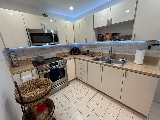 8251 NW 8th St Unit 214, Miami, FL 33126 - kitchen featuring stainless steel appliances, backsplash, light countertops, light tile patterned floors, and recessed lighting