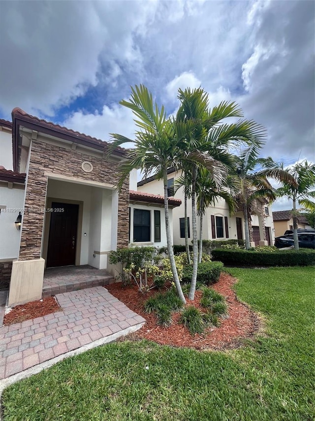 738 SE 37th Pl, Homestead, FL 33033 - mediterranean / spanish home with stucco siding, stone siding, and a front yard