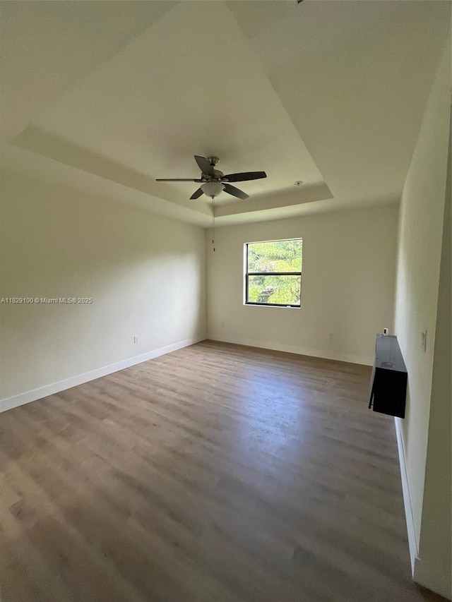 738 SE 37th Pl, Homestead, FL 33033 - empty room with a tray ceiling, wood finished floors, and a ceiling fan