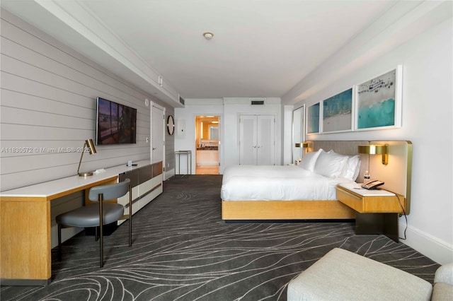 1 N Fort Lauderdale Beach Blvd Unit 1606, Fort Lauderdale, FL 33304 - bedroom with dark carpet, wooden walls, and ensuite bath