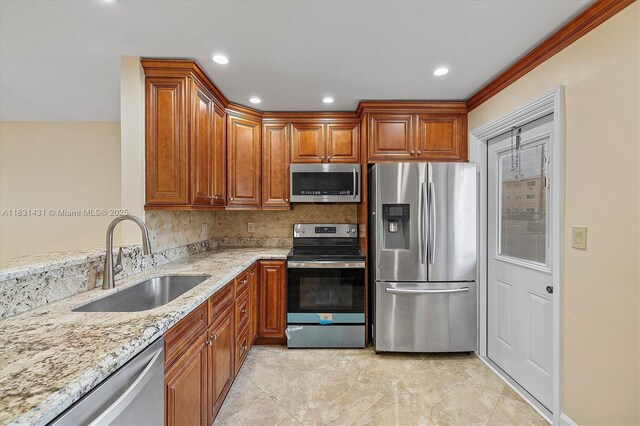 219 NE 14th Ave Unit 101, Hallandale Beach, FL 33009 - kitchen featuring stainless steel appliances, light stone counters, tasteful backsplash, brown cabinetry, and recessed lighting