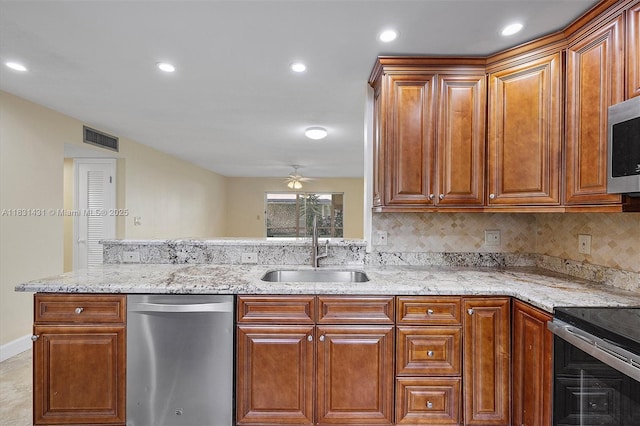 219 NE 14th Ave Unit 101, Hallandale Beach, FL 33009 - kitchen featuring appliances with stainless steel finishes, ceiling fan, light stone counters, recessed lighting, and decorative backsplash