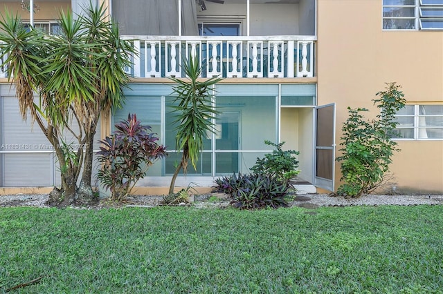 219 NE 14th Ave Unit 101, Hallandale Beach, FL 33009 - doorway to property with a balcony, a lawn, and stucco siding