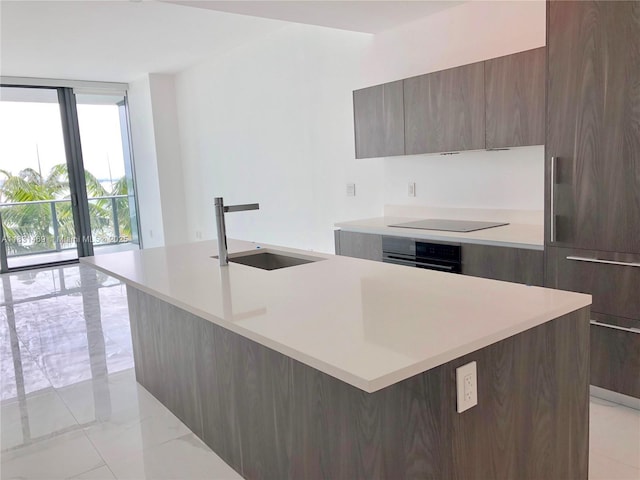 480 NE 31st St Unit 705, Miami, FL 33137 - kitchen featuring modern cabinets, black appliances, light countertops, a center island with sink, and expansive windows
