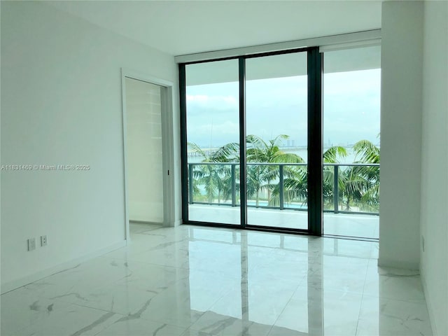 480 NE 31st St Unit 705, Miami, FL 33137 - empty room with floor to ceiling windows and light marble finish floors