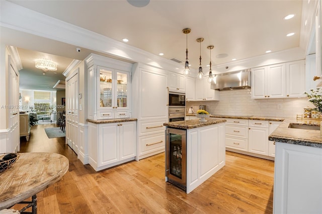 618 Valencia Ave Unit 101, Coral Gables, FL 33134 - kitchen featuring under cabinet range hood, beverage cooler, black appliances, ornamental molding, and dark stone counters