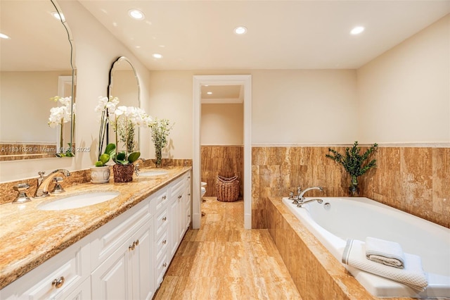 618 Valencia Ave Unit 101, Coral Gables, FL 33134 - bathroom featuring double vanity, a garden tub, recessed lighting, and a wainscoted wall