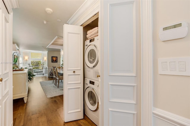 618 Valencia Ave Unit 101, Coral Gables, FL 33134 - laundry room featuring stacked washing machine and dryer, ornamental molding, and wood finished floors