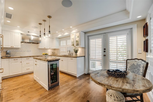 618 Valencia Ave Unit 101, Coral Gables, FL 33134 - kitchen featuring beverage cooler, under cabinet range hood, black electric stovetop, white cabinets, and crown molding