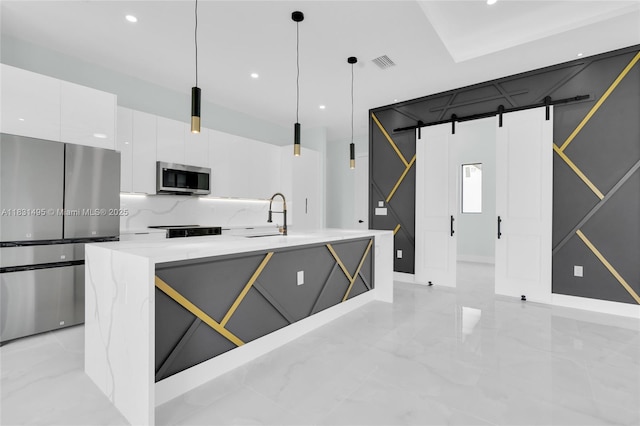 3209 45th St SW, Lehigh Acres, FL 33976 - kitchen with stainless steel appliances, a barn door, white cabinetry, modern cabinets, and hanging light fixtures