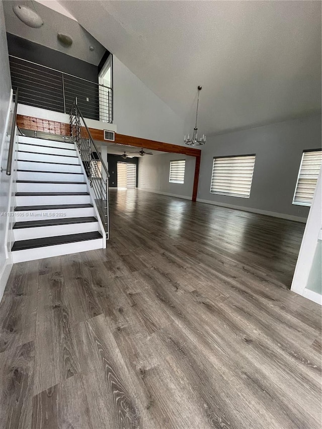 11123 SW 156th Ct, Miami, FL 33196 - unfurnished living room featuring a chandelier, stairway, wood finished floors, and high vaulted ceiling