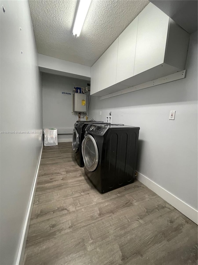 11123 SW 156th Ct, Miami, FL 33196 - laundry room featuring cabinet space, wood finished floors, water heater, washer and clothes dryer, and a textured ceiling