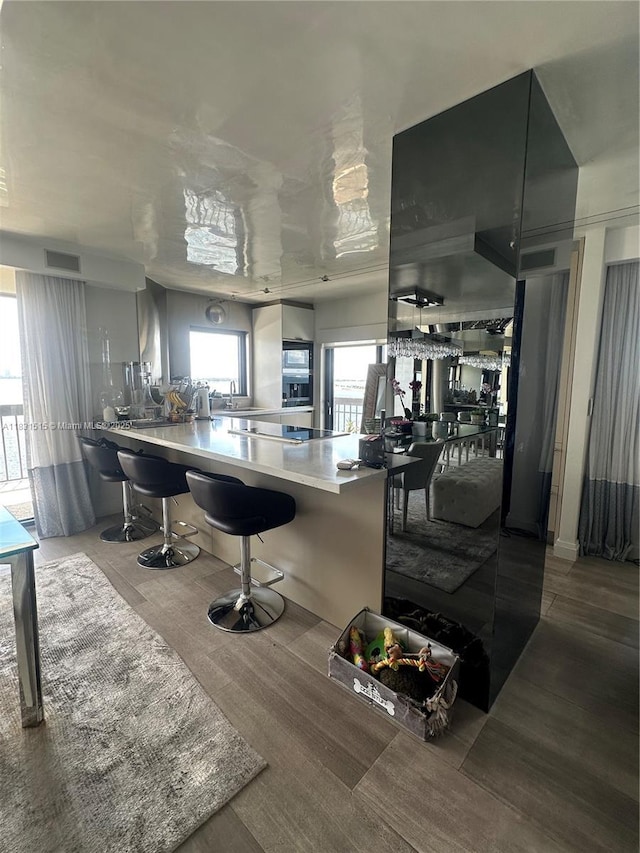 2333 Brickell Ave Unit 901, Miami, FL 33129 - kitchen featuring a kitchen bar, a peninsula, and wood finished floors