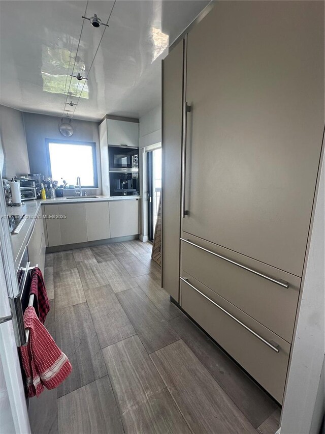 2333 Brickell Ave Unit 901, Miami, FL 33129 - kitchen with white cabinets, light wood-style flooring, stainless steel microwave, light countertops, and modern cabinets