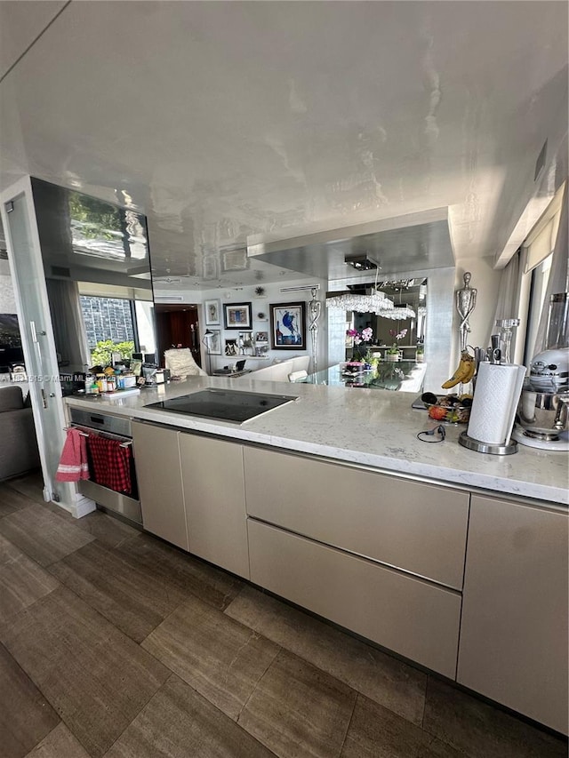2333 Brickell Ave Unit 901, Miami, FL 33129 - kitchen featuring oven, black electric stovetop, open floor plan, and light stone counters
