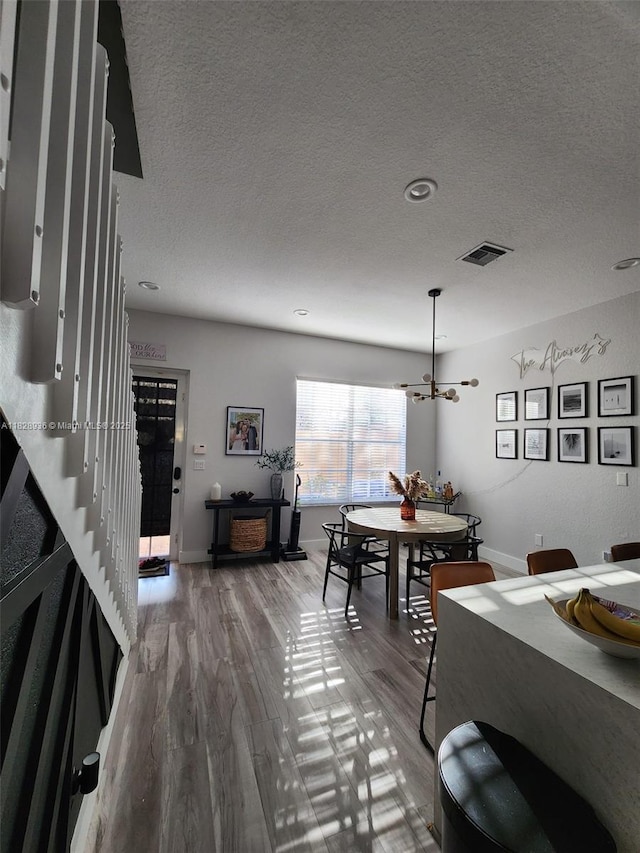 706 SW 147th Ave, Pembroke Pines, FL 33027 - dining space featuring a textured ceiling, wood finished floors, and a chandelier