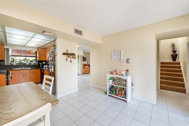 10114 NW 4th Ln Unit 3-12, Miami, FL 33172 - kitchen with dark countertops, light tile patterned floors, freestanding refrigerator, a textured ceiling, and range