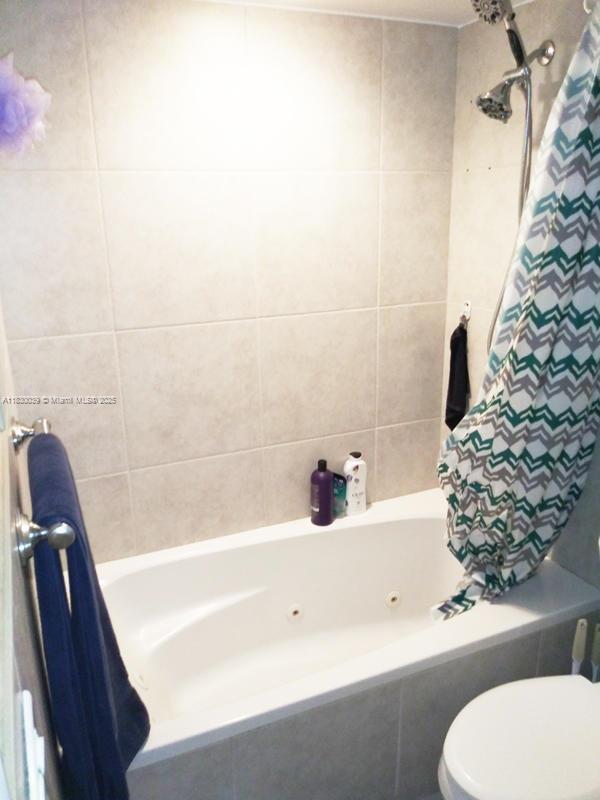 6289 Lear Dr Unit 308, Lake Worth, FL 33462 - full bathroom featuring toilet and a combined bath / shower with jetted tub