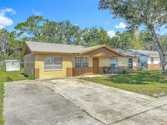 1206 E 27th St, Bradenton, FL 34208 - ranch-style house featuring a front lawn, stone siding, concrete driveway, and a porch
