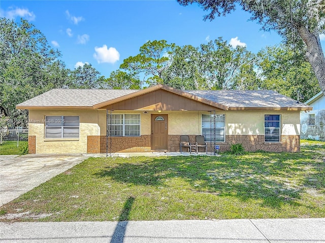 1206 E 27th St, Bradenton, FL 34208 - view of front facade featuring stone siding, a front lawn, stucco siding, and a porch