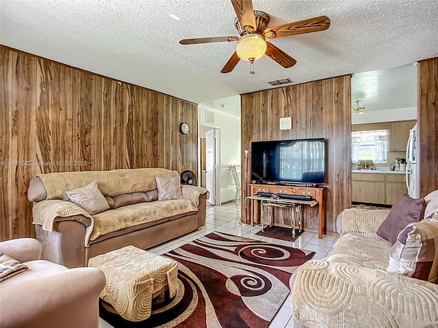 1206 E 27th St, Bradenton, FL 34208 - living area with a ceiling fan, wooden walls, light tile patterned floors, and a textured ceiling