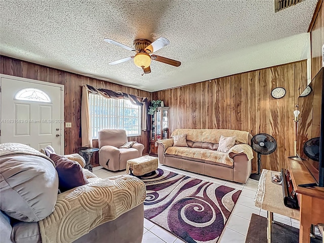 1206 E 27th St, Bradenton, FL 34208 - tiled living room with wooden walls, a ceiling fan, and a textured ceiling
