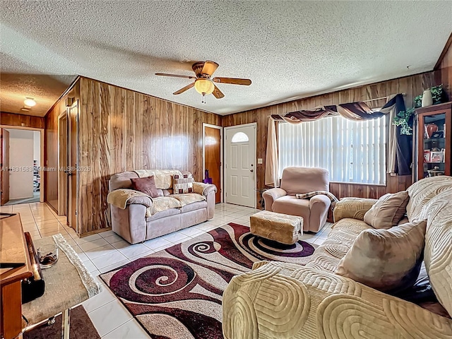 1206 E 27th St, Bradenton, FL 34208 - living room featuring wooden walls, a ceiling fan, light tile patterned flooring, and a textured ceiling