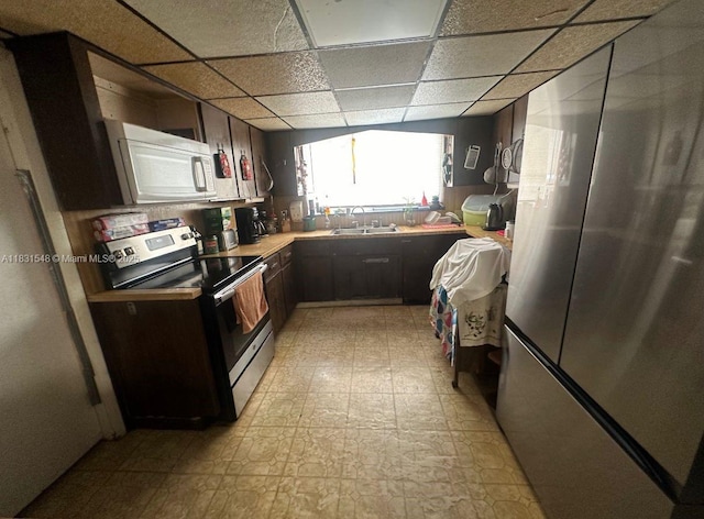 6641 Perry St, Hollywood, FL 33024 - kitchen with appliances with stainless steel finishes, light floors, a drop ceiling, light countertops, and dark brown cabinetry