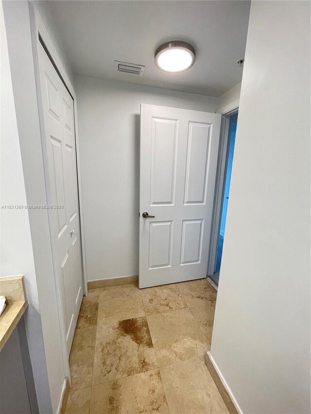 2650 SW 37th Ave Unit 603, Miami, FL 33133 - hall featuring baseboards and stone finish floors