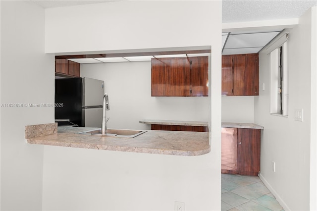 20905 NE 8th Ct Unit 101-36, Miami, FL 33179 - kitchen featuring freestanding refrigerator, a peninsula, light countertops, and light tile patterned floors