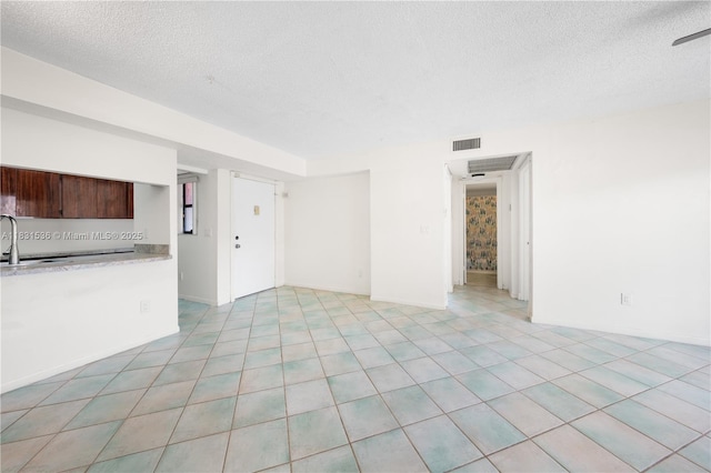 20905 NE 8th Ct Unit 101-36, Miami, FL 33179 - unfurnished living room with a textured ceiling and light tile patterned floors