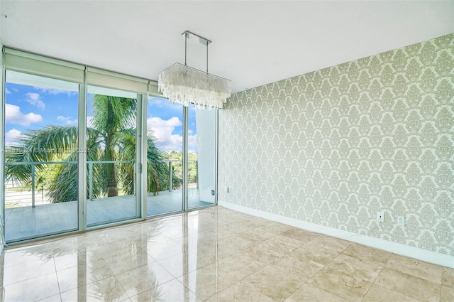 6305 Indian Creek Dr Unit 3B, Miami Beach, FL 33141 - empty room featuring wallpapered walls, a wall of windows, healthy amount of natural light, and a chandelier