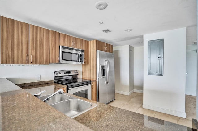 6305 Indian Creek Dr Unit 3B, Miami Beach, FL 33141 - kitchen with appliances with stainless steel finishes, brown cabinets, light tile patterned floors, and electric panel
