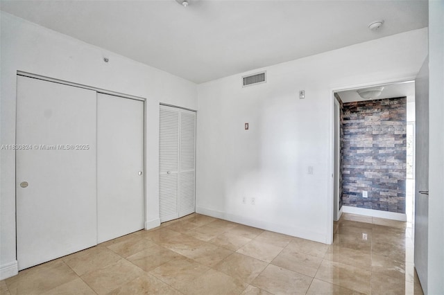 6305 Indian Creek Dr Unit 3B, Miami Beach, FL 33141 - unfurnished bedroom with multiple closets and light tile patterned floors