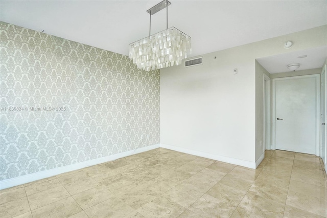 6305 Indian Creek Dr Unit 3B, Miami Beach, FL 33141 - unfurnished room featuring wallpapered walls, an accent wall, a smoke detector, and a chandelier