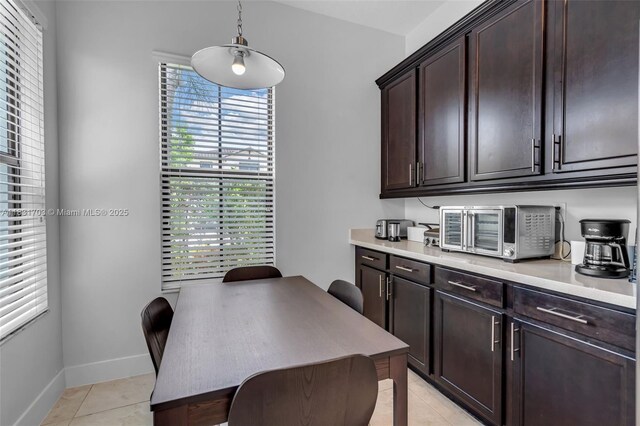 3274 W 96th Pl, Hialeah, FL 33018 - kitchen featuring light tile patterned floors, dark brown cabinetry, light countertops, and pendant lighting