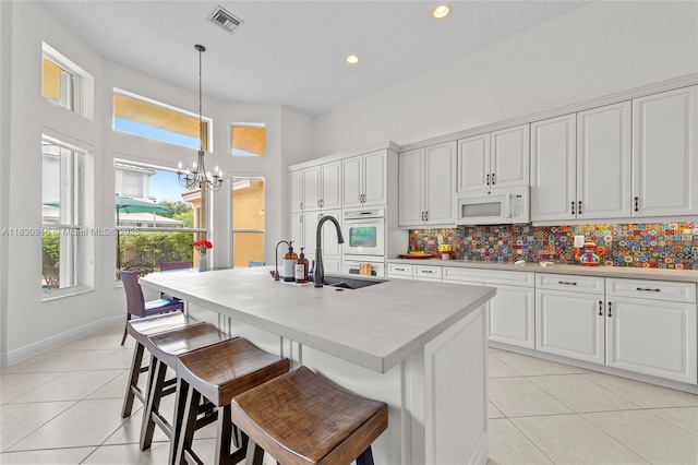 19442 SW 39th St, Miramar, FL 33029 - kitchen featuring white appliances, light tile patterned flooring, a chandelier, healthy amount of natural light, and recessed lighting