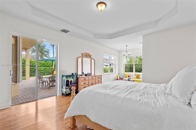 19442 SW 39th St, Miramar, FL 33029 - bedroom with a raised ceiling, access to exterior, light wood-style flooring, and a chandelier