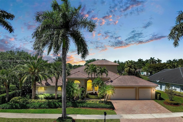 2541 Golf View Dr, Weston, FL 33327 - mediterranean / spanish house featuring decorative driveway, an attached garage, a tiled roof, and stucco siding