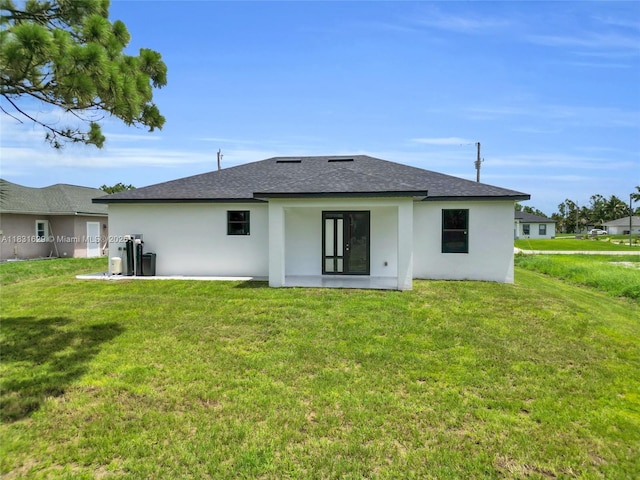 2505 40th, Lehigh Acres, FL 33976 - back of property featuring stucco siding, a shingled roof, and a yard