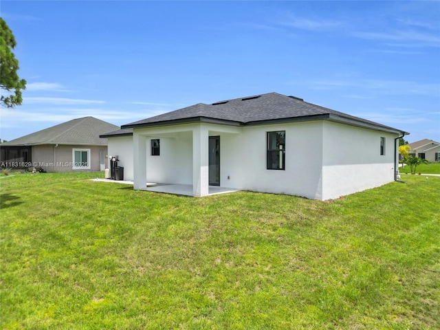 2505 40th, Lehigh Acres, FL 33976 - rear view of house featuring stucco siding, roof with shingles, a patio area, and a yard